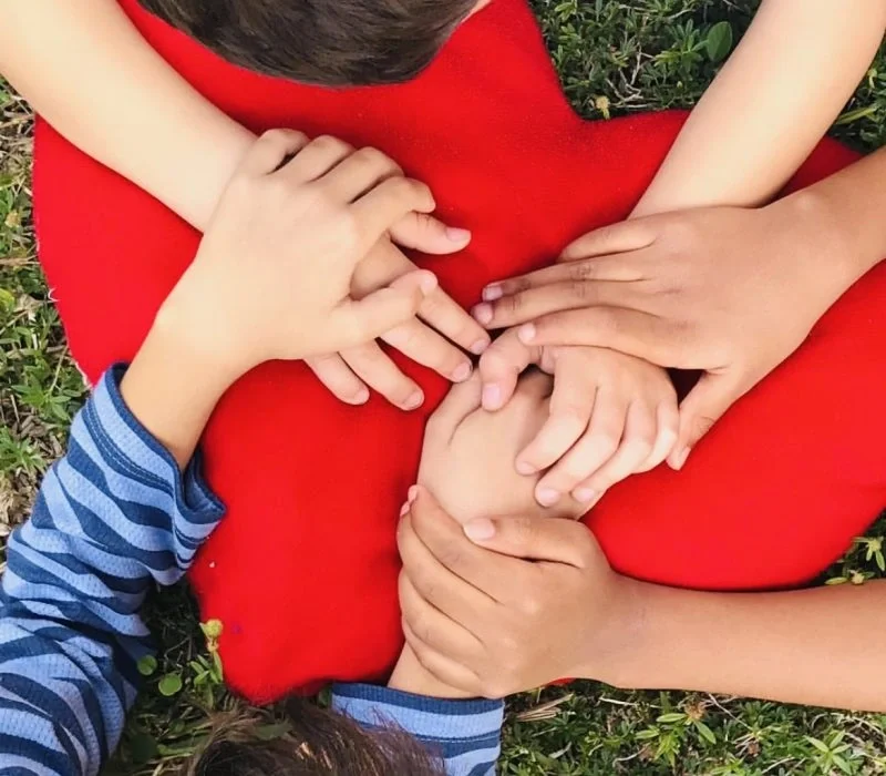 Children with their hands on a heart
